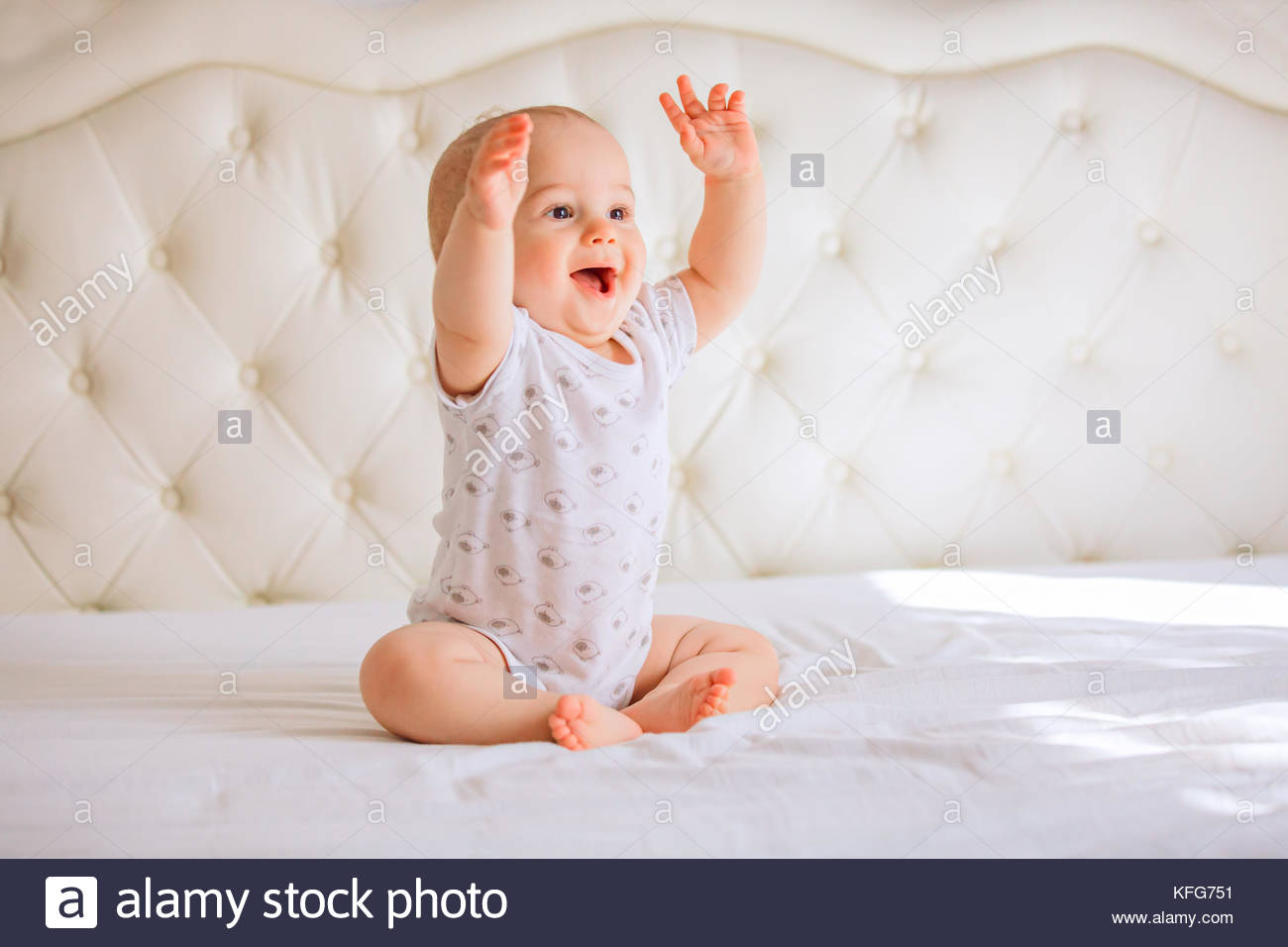 Adorable baby boy in white sunny bedroom